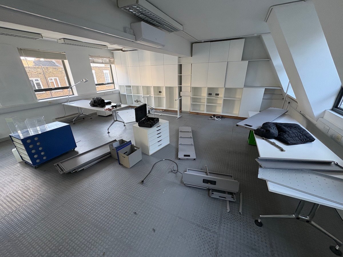 Office fit-out clearance before photo in Fitzrovia W1T showing dismantled furniture and MDF panels