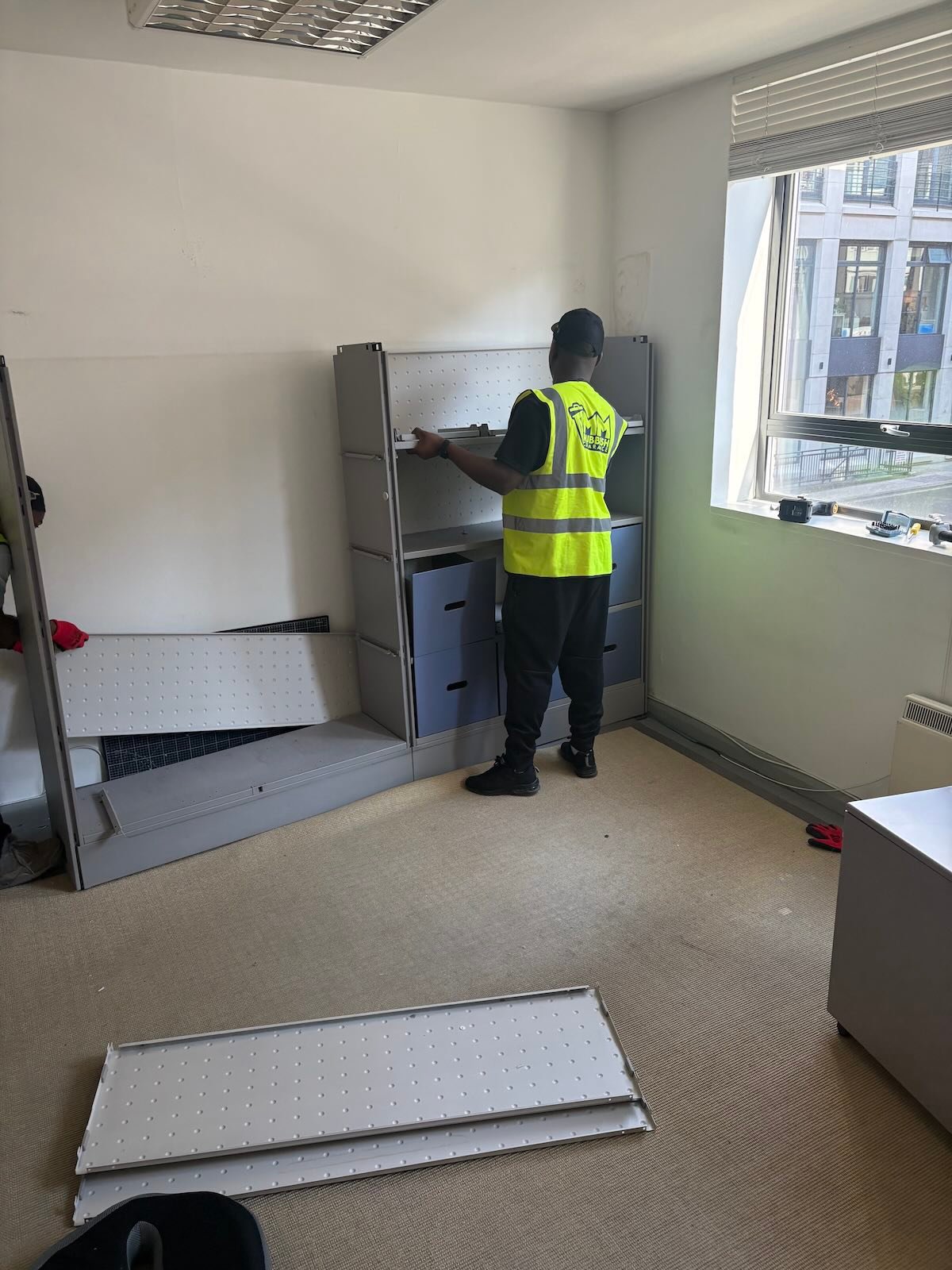Office clearance process photo in Fitzrovia W1T showing team loading dismantled office furniture