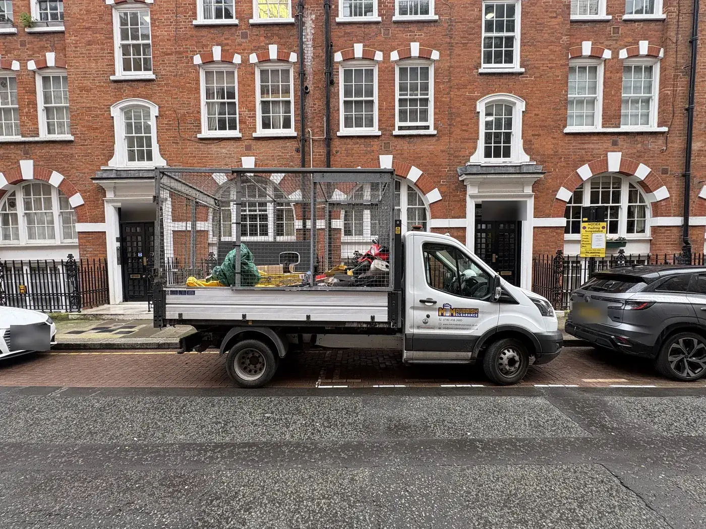 MM Rubbish Clearance caged tipper vehicle parked on Hanson Street, Fitzrovia, during a collection.