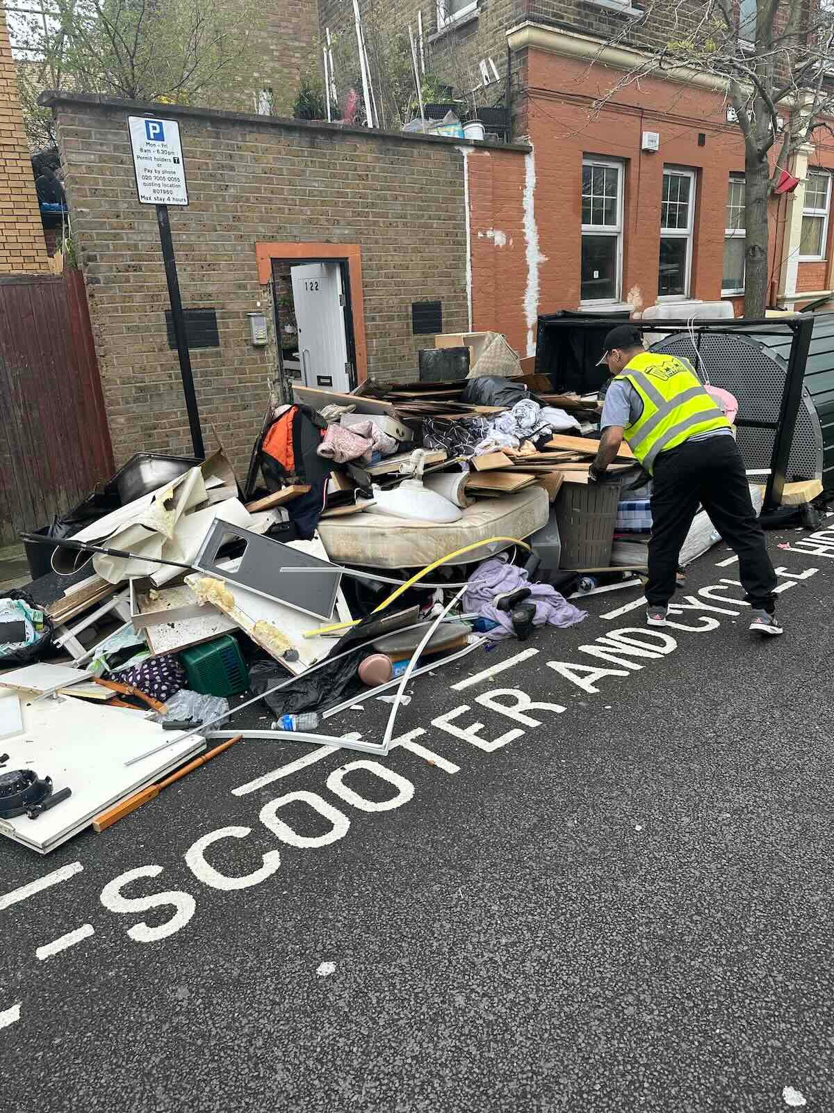 MM Rubbish Clearance team member in branded hi-vis loading end of tenancy waste in Peckham SE15