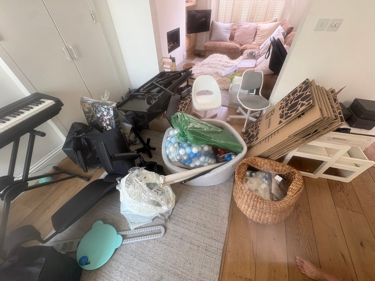 Mixed household contents covering the floor of a flat on Chetwynd Road, NW5, before clearance
