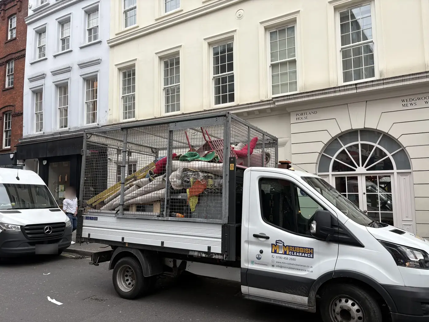MM Rubbish Clearance branded vehicle loaded with collected materials in Soho, London.