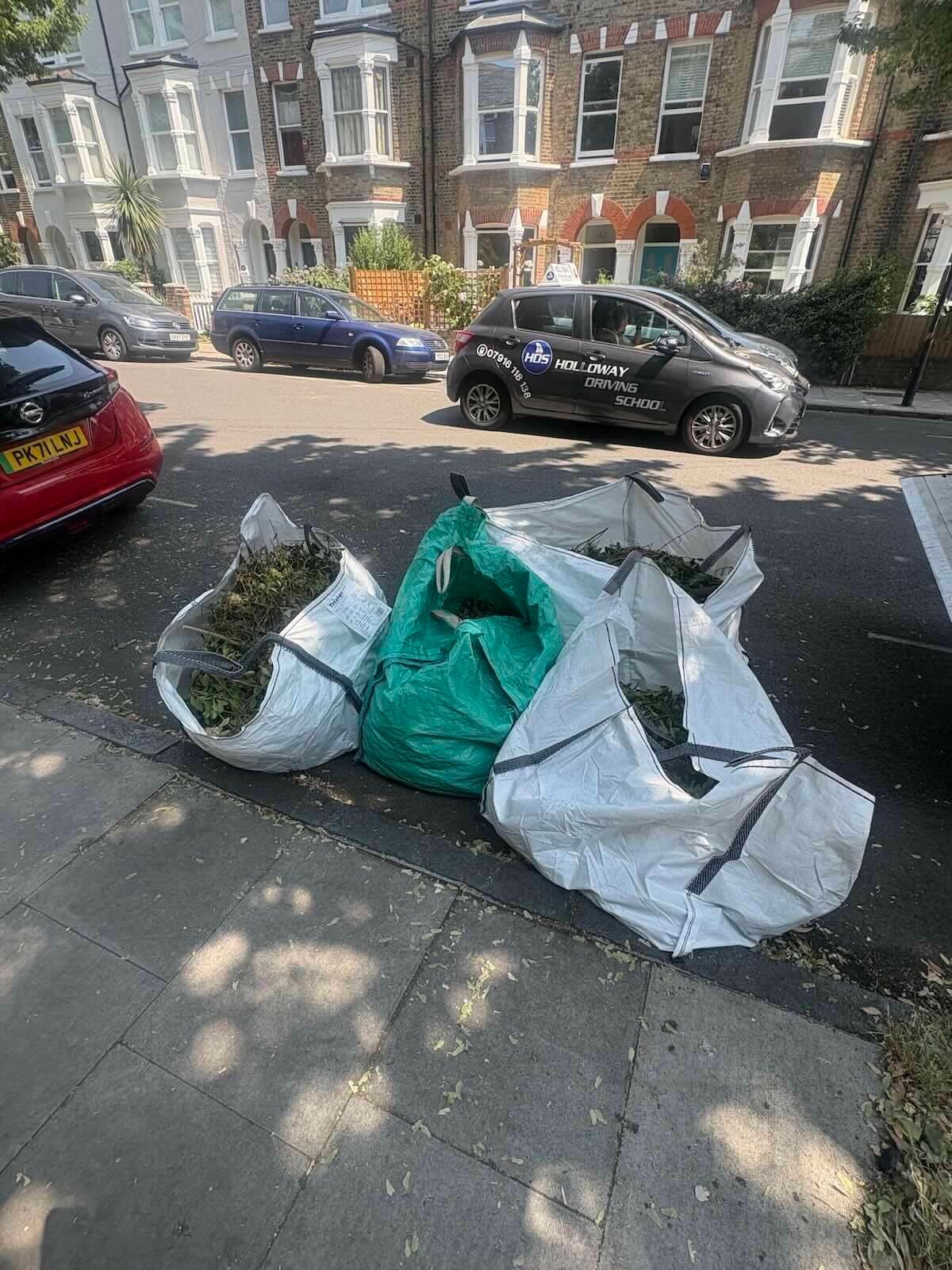 Four bulk bags of garden cuttings at the kerb on a residential street in Archway N19 before collection